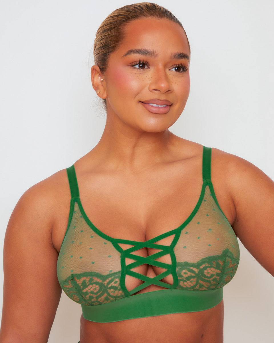 Close-up of the Abigail bralette in Amazon Green, highlighting the sheer polka-dot mesh cups, floral lace trim, criss-cross front strap detail, soft underband, and adjustable shoulder straps.
