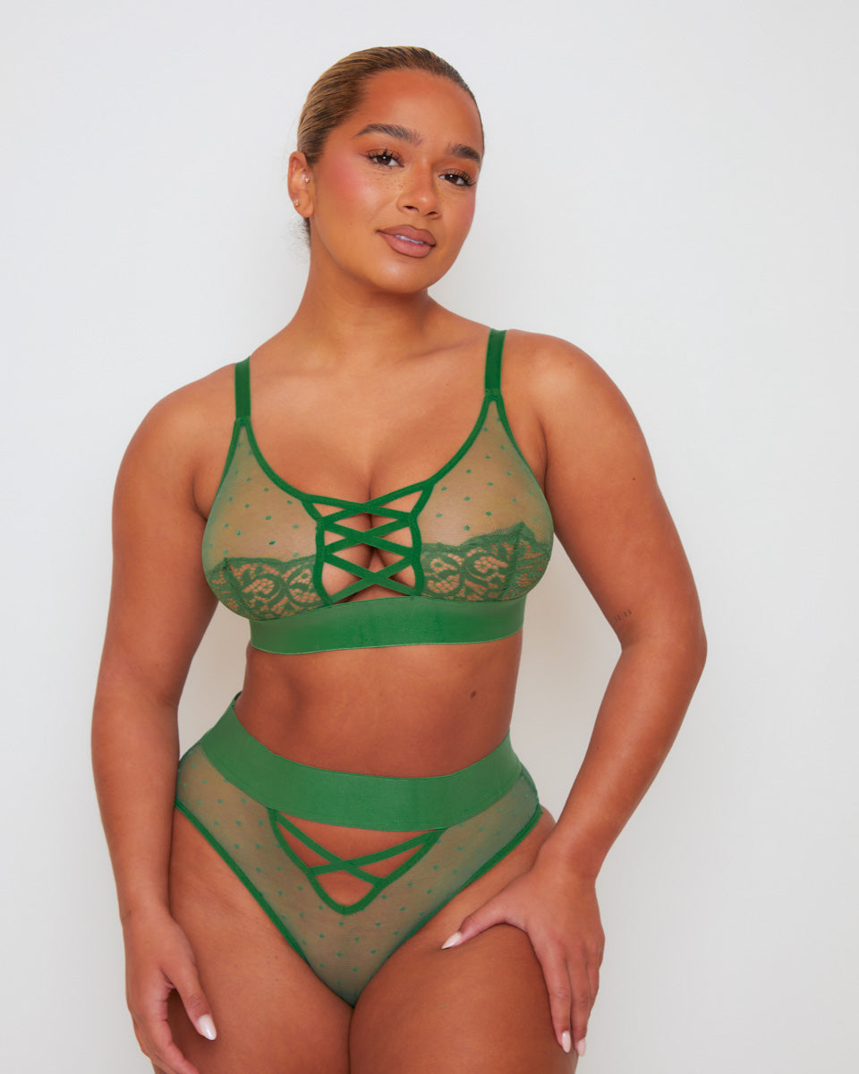 Front view of the Abigail lingerie set in Amazon Green, showcasing a sheer mesh bralette with lace-trimmed cups and criss-cross strap detailing, paired with a high-waisted brief featuring sheer polka-dot mesh panels and decorative strappy accents.