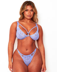 Model wearing Tutti Rouge Artemis pale blue lace plunge bra and matching thong with strappy detailing.