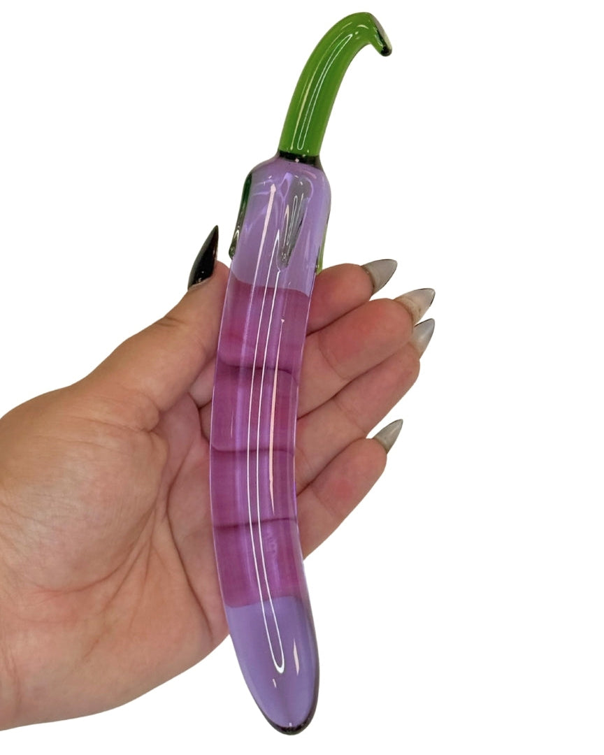 Purple Glass Toy from Brand X By Tutti inspired by the shape and look of an aubergine in a hand for size context