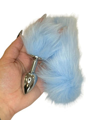 Blue fur butt plug held in a hand against a white background