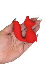 Red cat-shaped object held in a hand with a white background