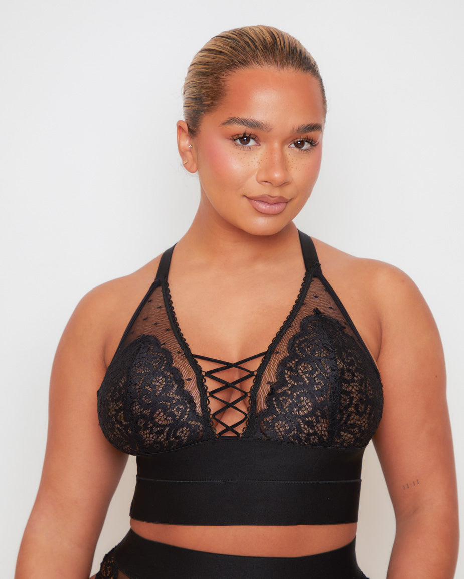 Front close-up of the Tutti Rouge Maya Bralette in Midnight Black featuring soft floral lace, sheer dotted mesh, a plunging neckline and signature lace-up front detail.