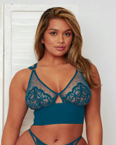Front view of the Morgon Bralette in Blue Coral, featuring sheer polka-dot mesh, floral lace cups, and a delicate centre-front keyhole detail. The wide underband provides a supportive fit while maintaining a contemporary, feminine look.