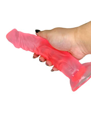 Hand holding a frosted pink silicone product against a white background