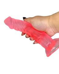 Hand holding a frosted pink silicone product against a white background