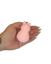 Hand holding a pink silicone product on a white background