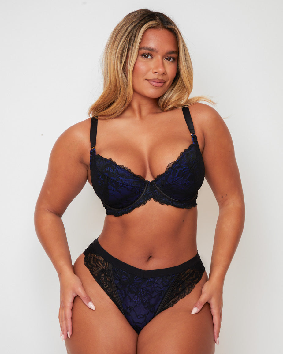 Front view of the Tutti Rouge Ramona Padded Plunge Lace Bra in Midnight Black & Devil Blue paired with the matching Ramona High Waist Brazilian Brief, combining supportive plunge shaping with striking blue floral lace and sheer black details.
