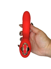 Red toy with a gold emblem held by a hand on a white background