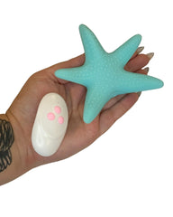 Hand holding a turquoise star-shaped object against a white background
