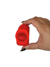 Hand holding a red silicone vibrator against a white background
