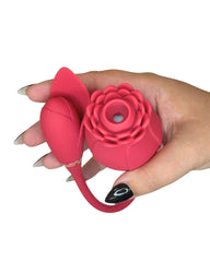 Hand holding a pink silicone flower-shaped vibrator toy on a white background