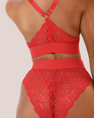 Model wearing the Hallie Bralette and Brazilian Brief Set in Chilli Pepper Red from Tutti Rouge, shown from the back. The set features floral lace detailing, a racerback design with gold-tone heart hardware, and a high-waisted Brazilian brief.
