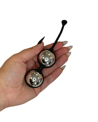 Metallic silver Kegel balls in hand for size context