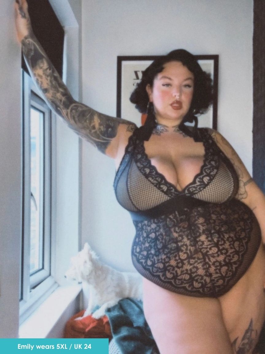 Person wearing a black lace lingerie set in a room with a window and framed picture.