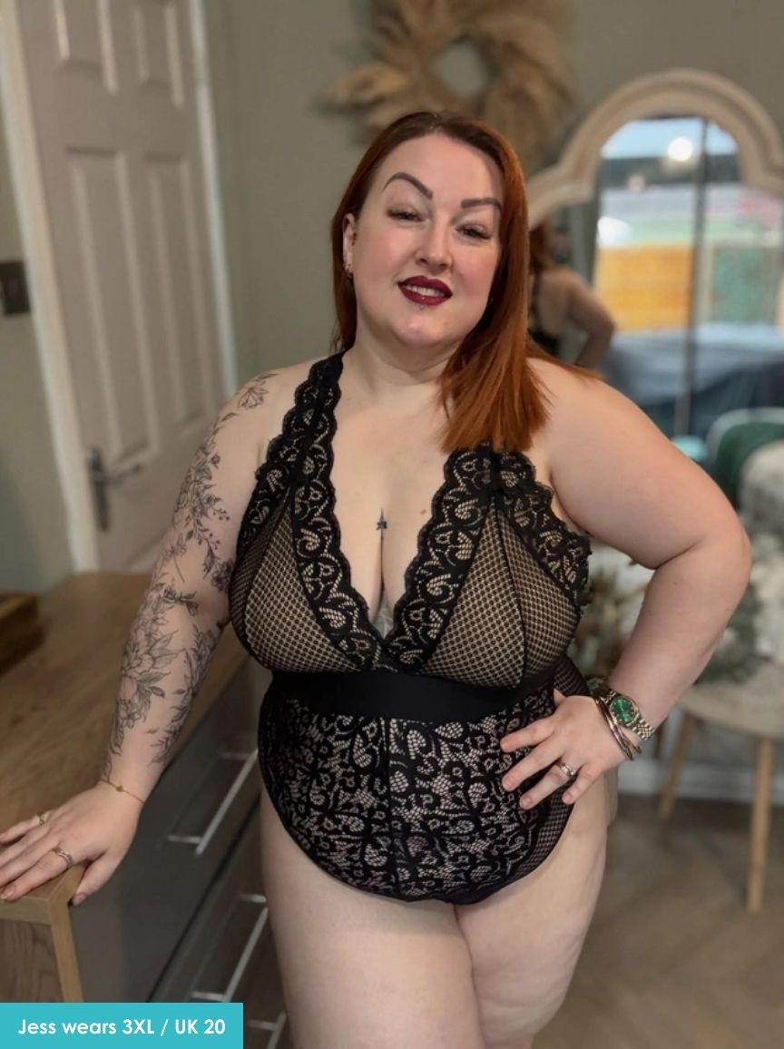 Woman wearing a black lace bodysuit in a home setting