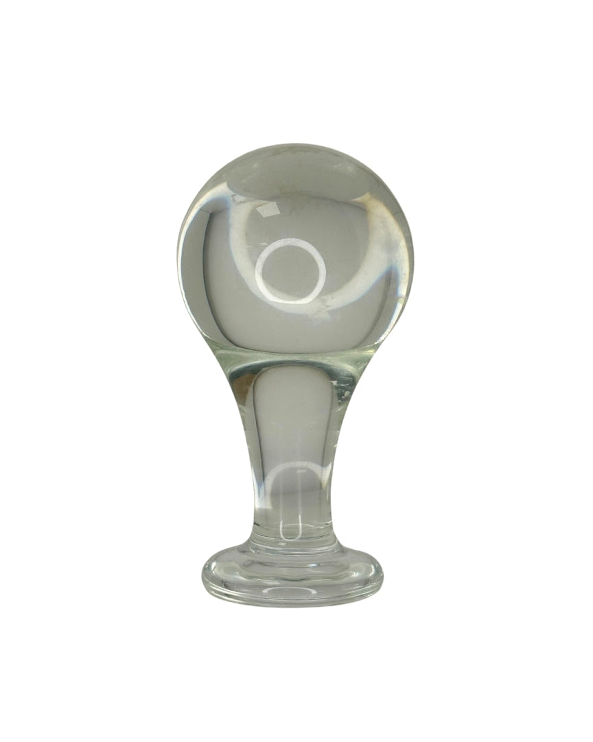 Clear glass butt plug with a rounded top and cylindrical base on a white background