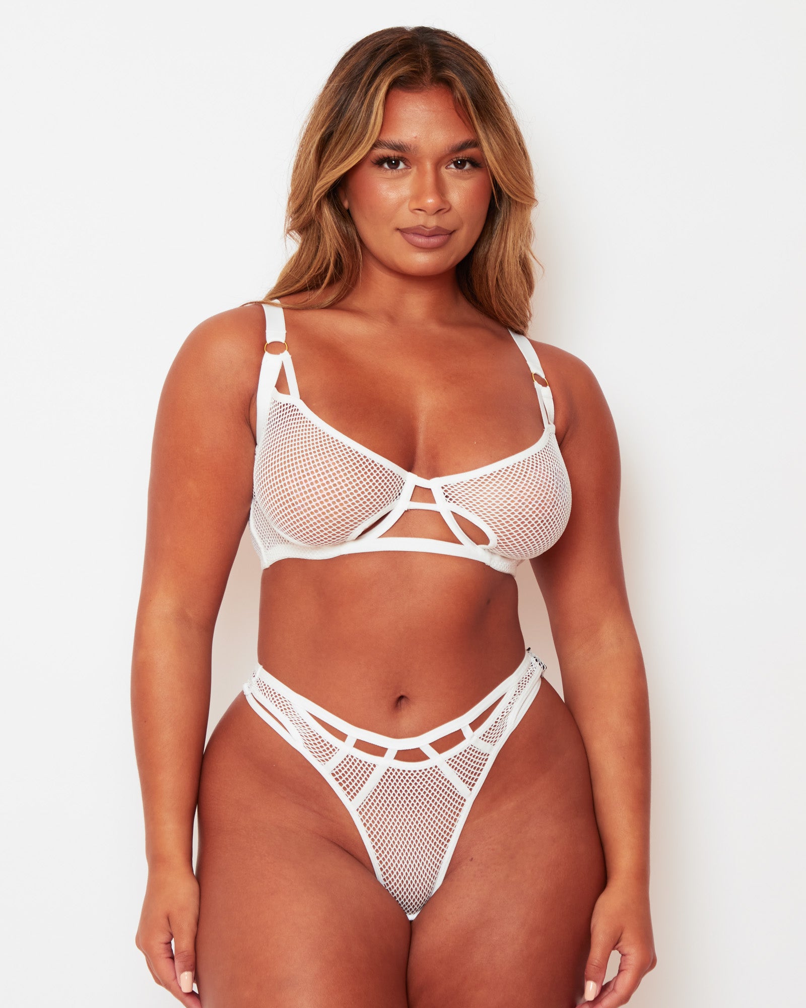 Front view of the Tutti Rouge Aphrodite white fishnet bra and thong set, featuring geometric cut-outs and high-cut legs.