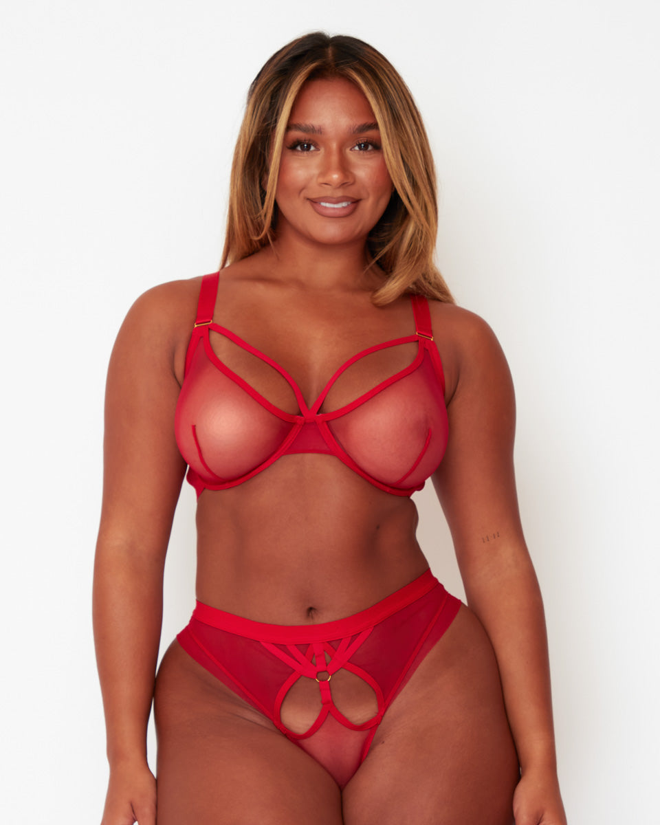 Model wearing the Tutti Rouge Carina Sheer Bra and matching briefs in Sheer Strawberry, supportive DD+ lingerie with sheer mesh cups and contemporary strappy details.