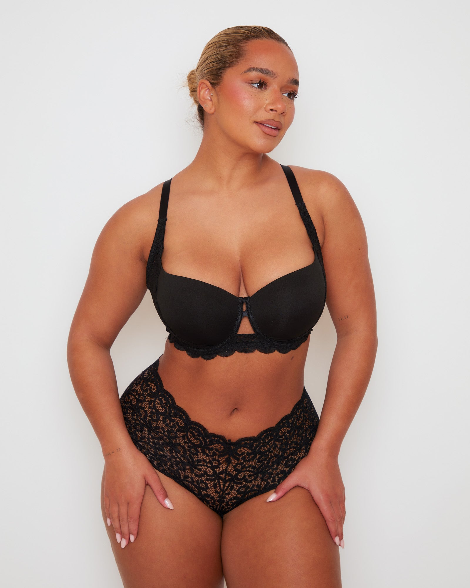 Front view of Tutti Rouge Daley bra in Midnight Black with centre cut-out detailing, worn with coordinating floral lace briefs.