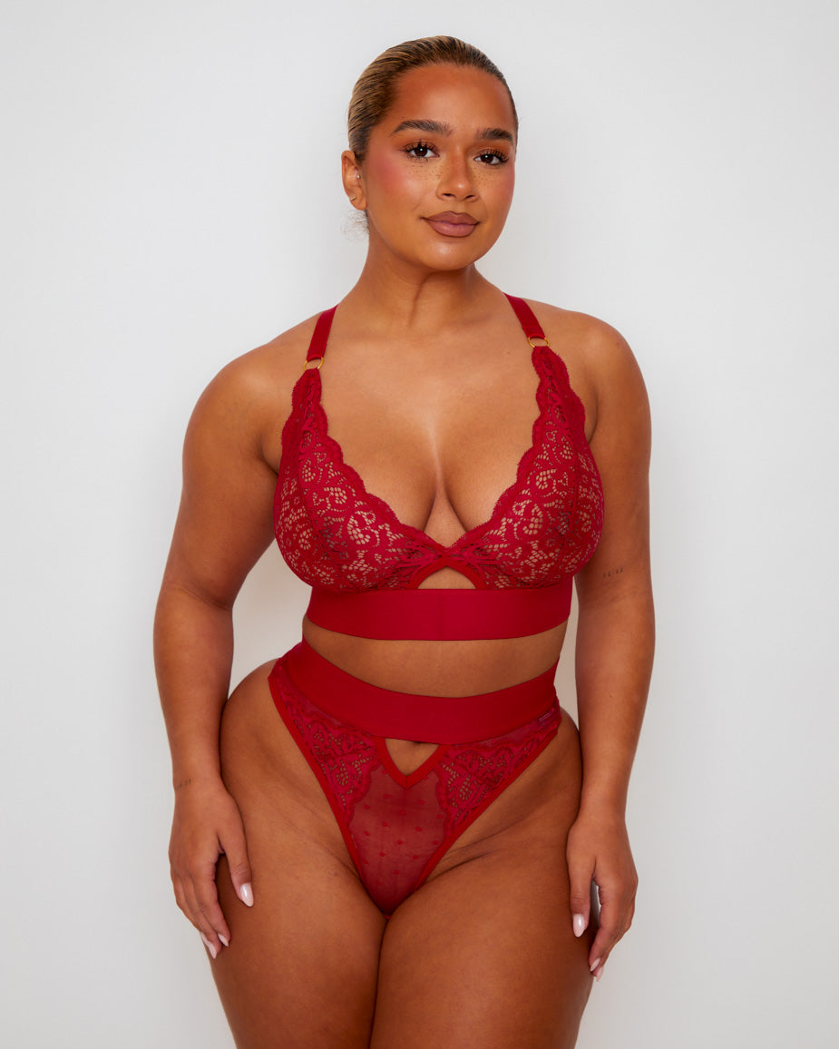 Model wearing the Tutti Rouge Julisa Fuller Bust Bralette and Brazilian Brief Set in Raspberry Red featuring floral lace, sheer dotted mesh and a flattering high-waist Brazilian brief.