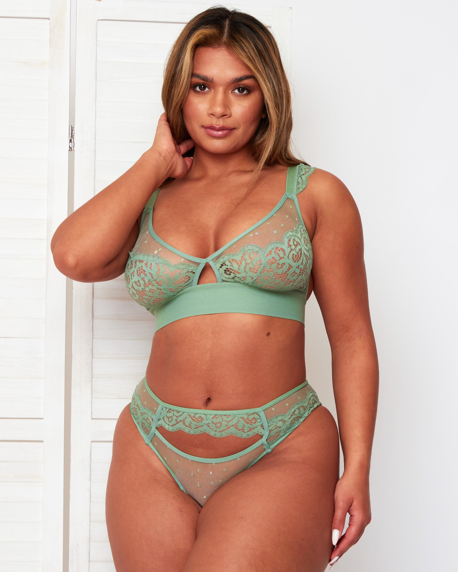 Model wearing the Tutti Rouge Kaitlin Bralette in Basil Green, featuring lace cups, spot mesh and a wide underband.