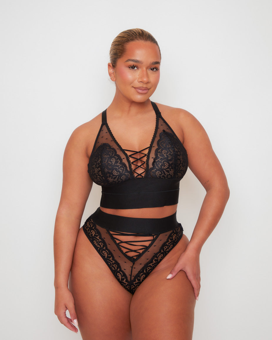 Front view of the Tutti Rouge Maya Bralette in Midnight Black paired with the matching Maya High Waist Brief, featuring floral lace, sheer dotted mesh and statement lace-up detailing.