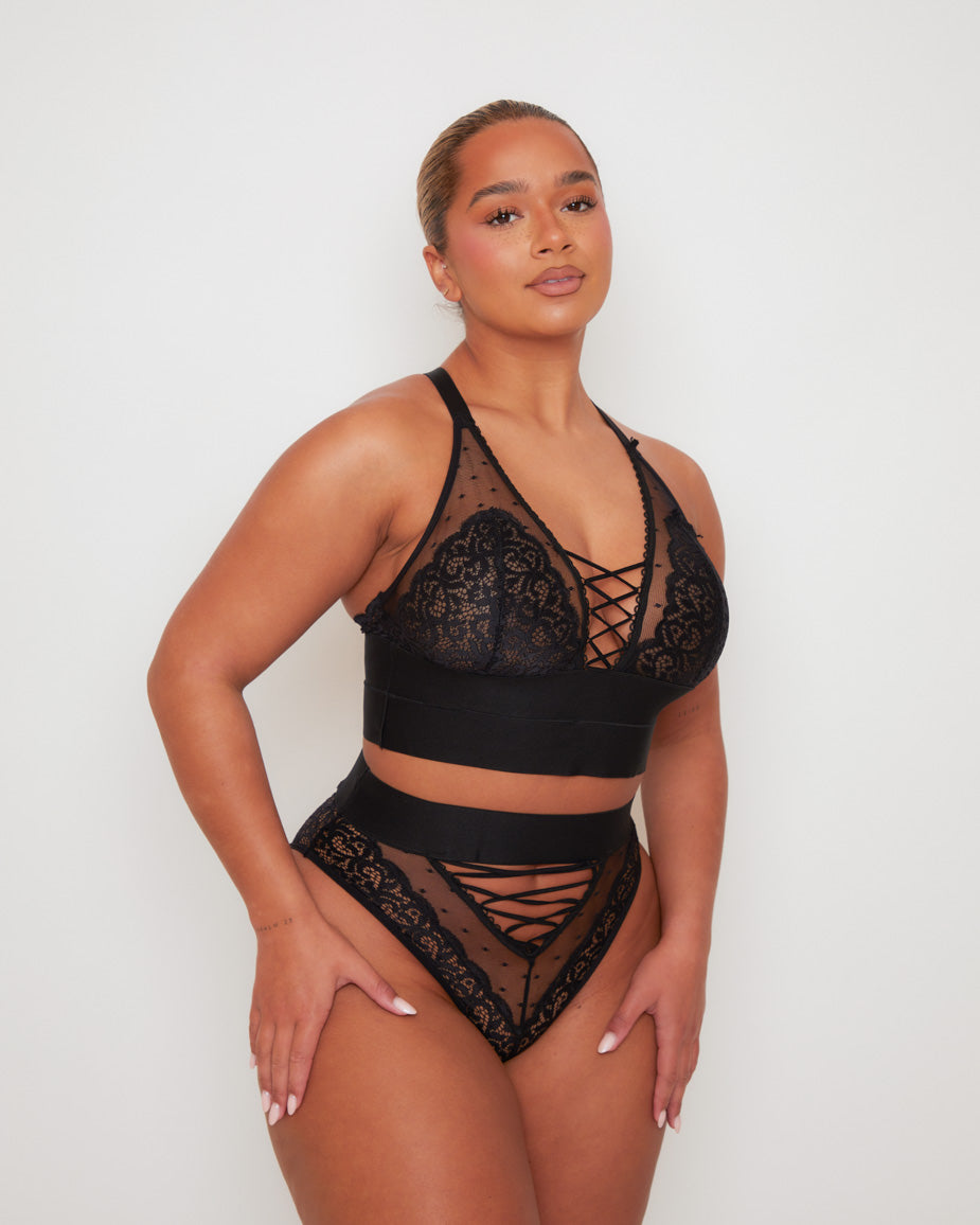 Side profile of the Tutti Rouge Maya Bralette in Midnight Black paired with the matching Maya High Waist Brief, showcasing delicate floral lace, sheer dotted mesh and bold lace-up details.