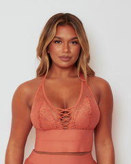 Front view of the Maya Bralette & Brief Set in Cider Orange, showcasing delicate floral lace, sheer dotted mesh, and elegant lace-up detailing that creates a flattering, feminine silhouette.