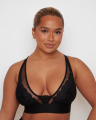 Front close-up of the Tutti Rouge Riley Bralette in Midnight Black highlighting the deep plunge silhouette, floral lace cups, sheer dotted mesh and soft elastic underband.