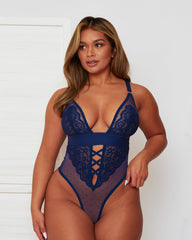 Front view of the Tutti Rouge Stormy Bodysuit in Oceanic Blue featuring floral lace cups, sheer dotted mesh, plunging neckline, criss-cross front detail and high-leg thong design.