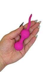 Pink silicone ball with a loop held in a hand on a white background