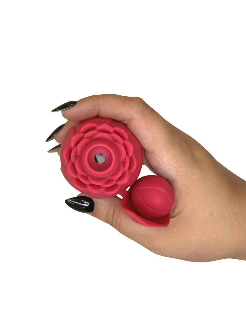 Hand holding a red silicone flower-shaped product on a white background