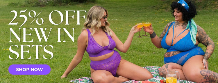 Two models wearing Tutti Rouge lingerie sets in vibrant purple and electric blue sit on a picnic blanket outdoors, raising glasses together. Promotional text reads “25% Off New In Sets” with a “Shop Now” call-to-action button.