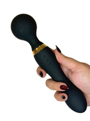 Black handheld device with gold accent held by a hand on a white background